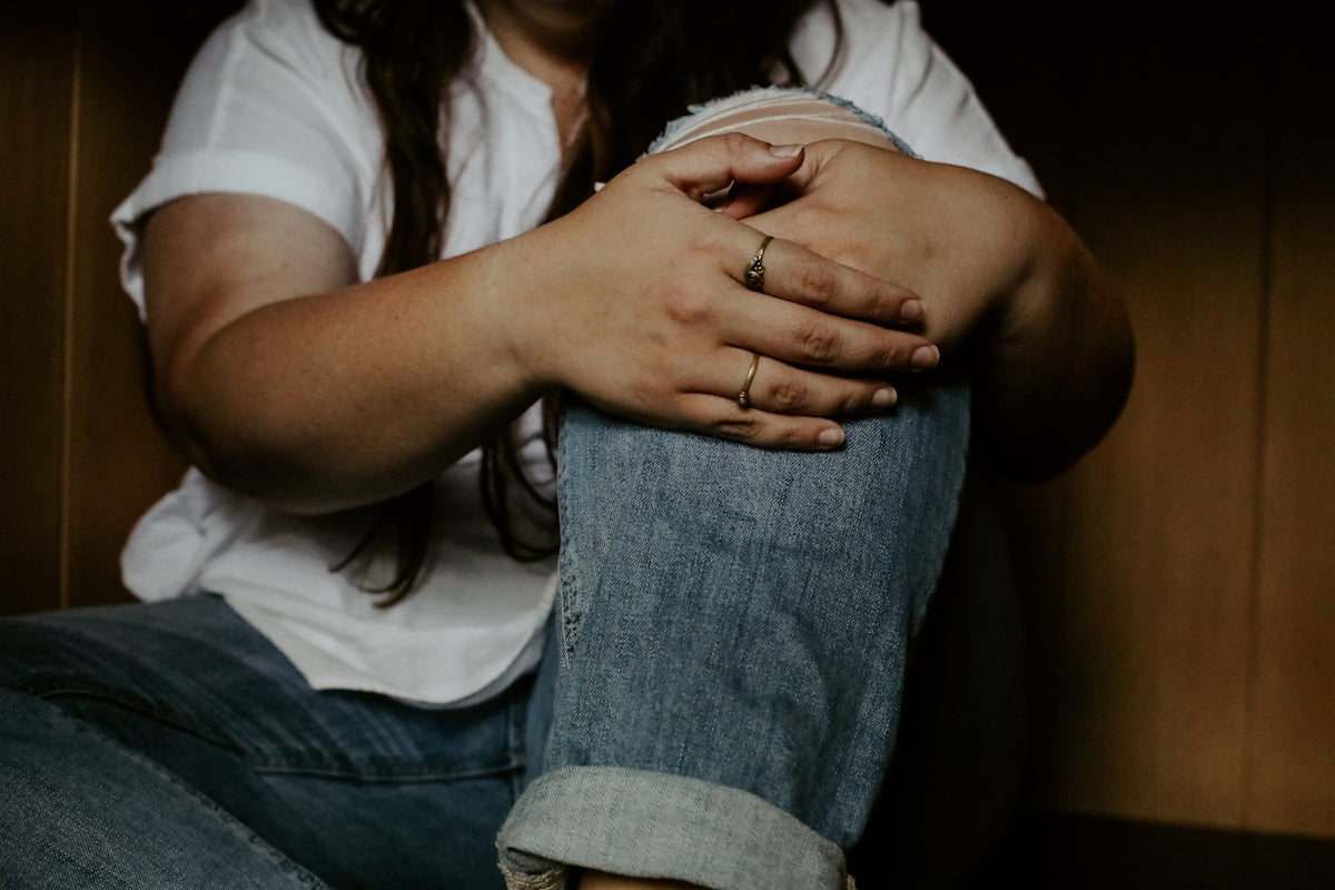 a woman sitting on the floor with her hands on her knees